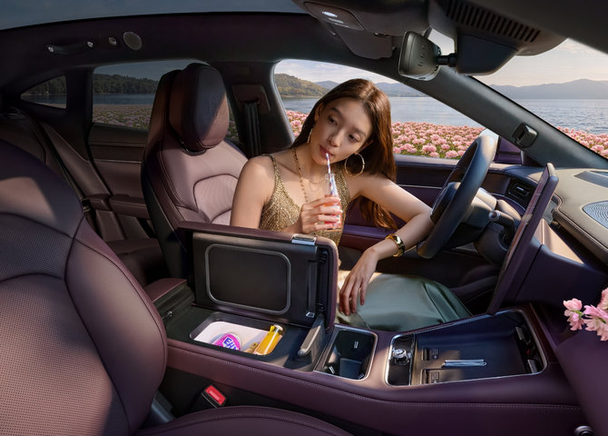 User sitting in the driver's seat of the SAIC Z7-Z7T enjoying a drink, showcasing the vehicle's in-car fan-cooled refrigerator