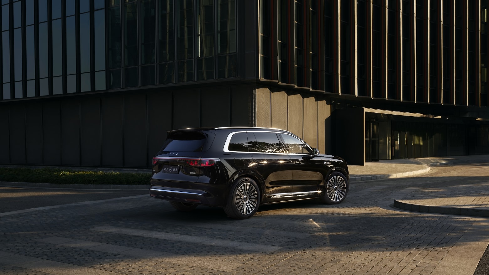 An AITO M8 in Obsidian Black drives on an urban road