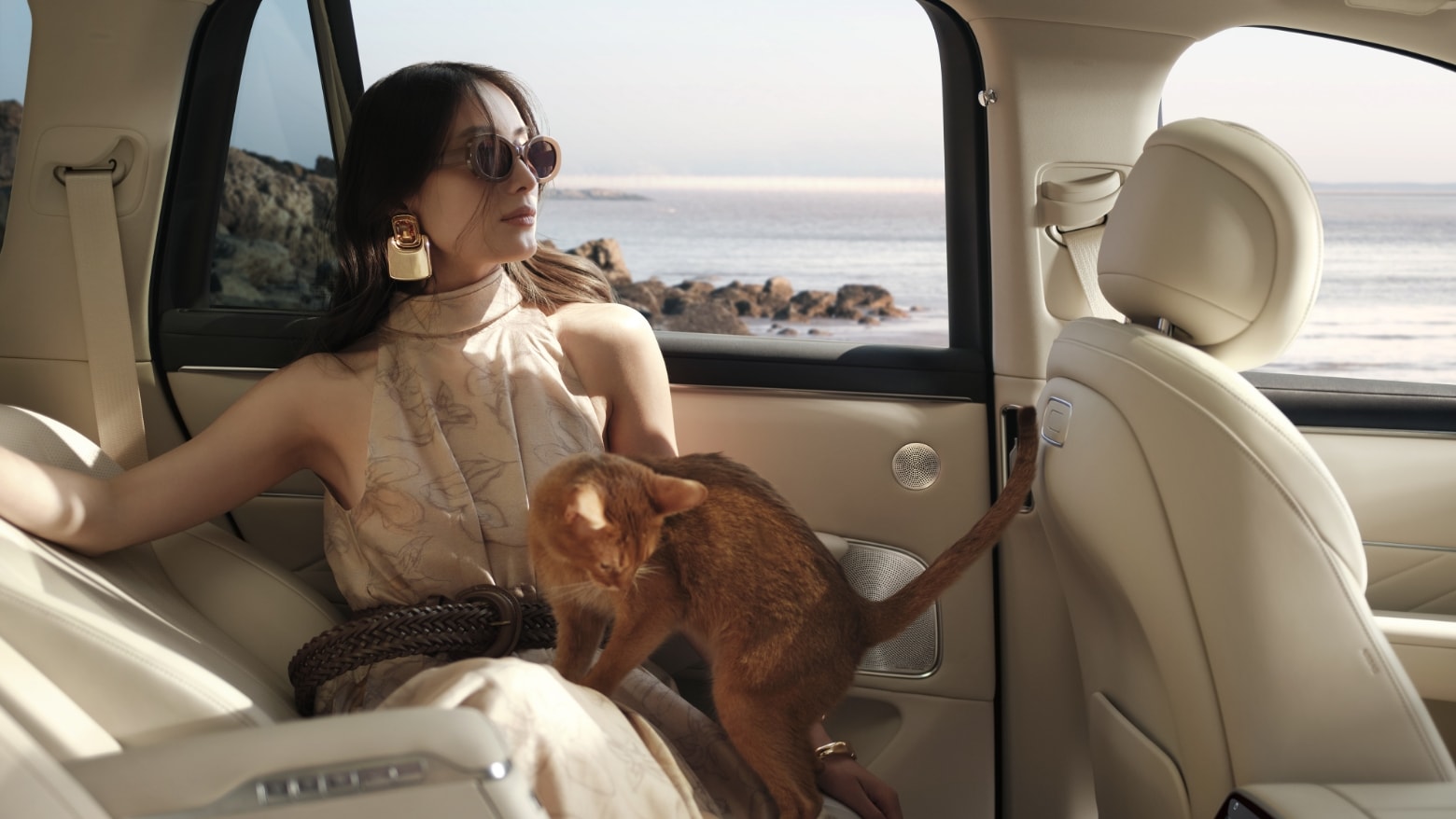 A woman relaxes inside an AITO M8 in White Apricot interior