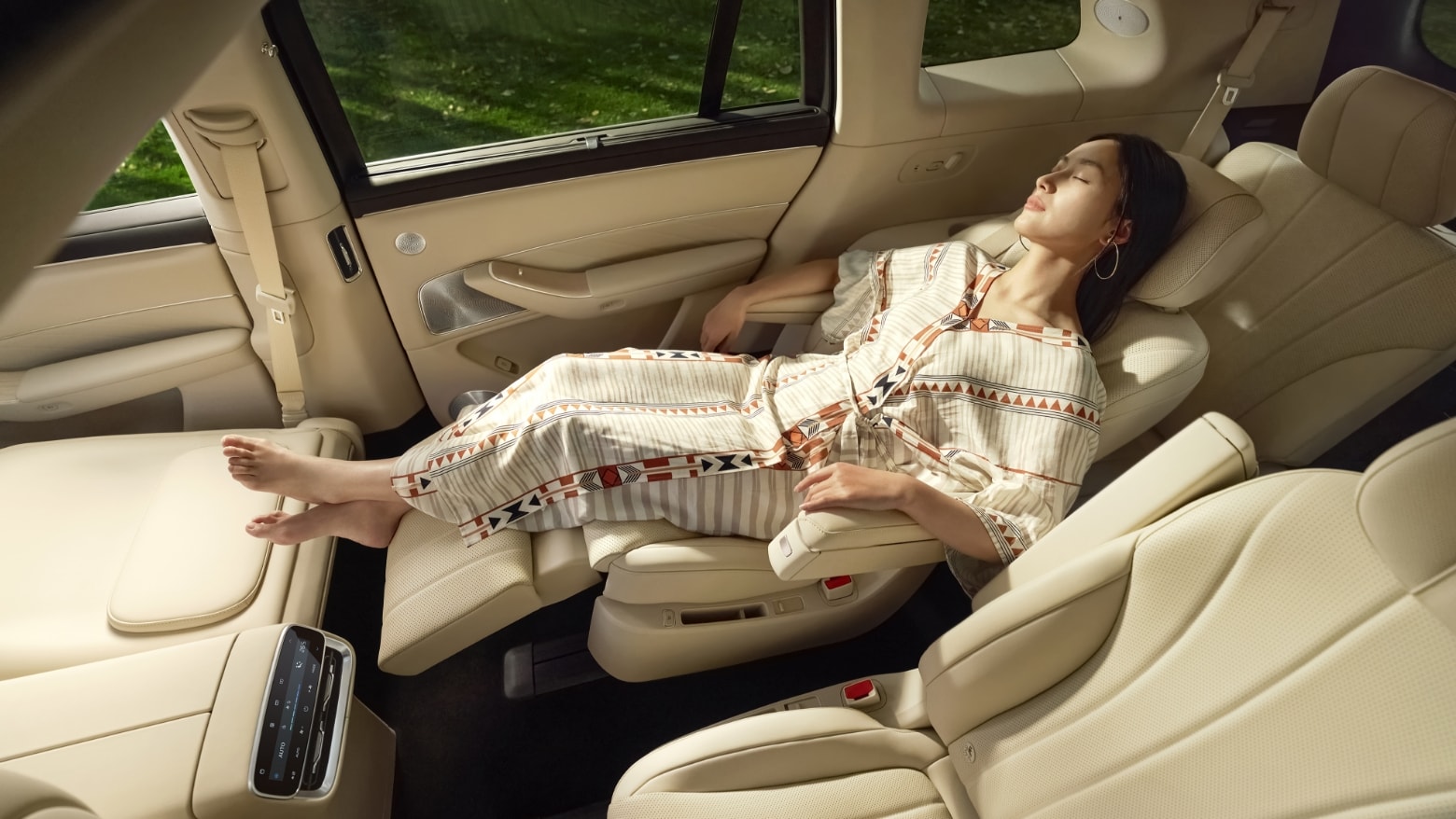 A woman reclining on the unfolded second-row zero-gravity seat in AITO M8 White Sand Apricot