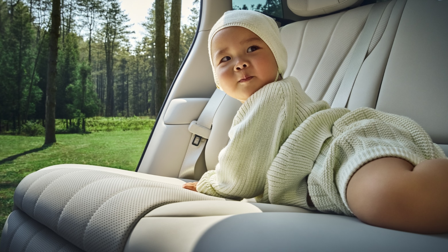 A baby rests on the rear seats of an AITO M8 in White Apricot interior