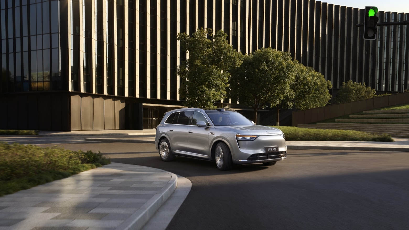 An AITO M8 in Galaxy Silver navigates a sharp turn on an urban road