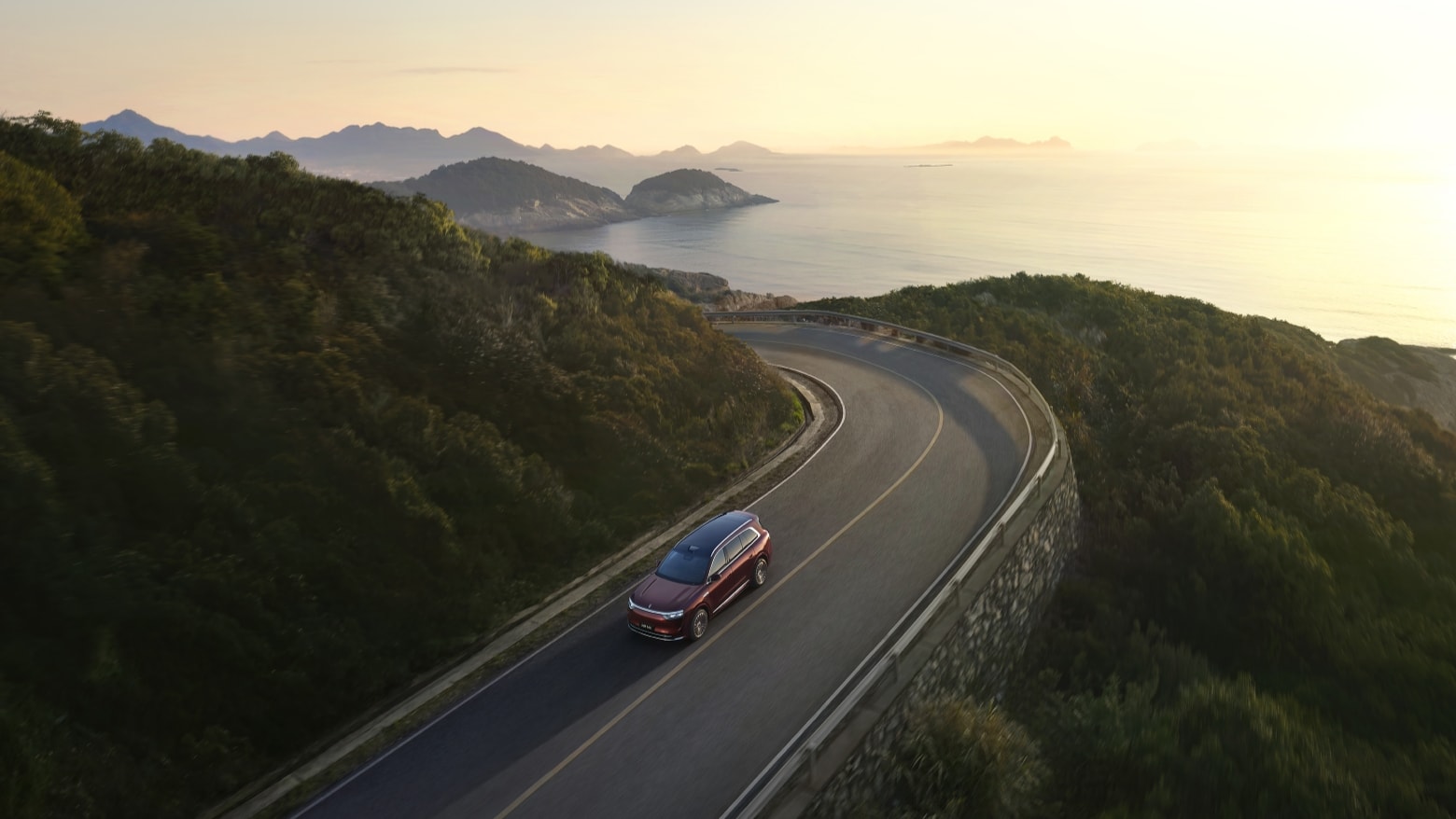 An AITO M8 in Sunset Glow drives on a mountain road
