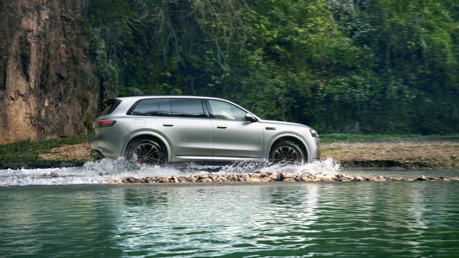 An AITO M8 in Galaxy Silver drives through a waterlogged road