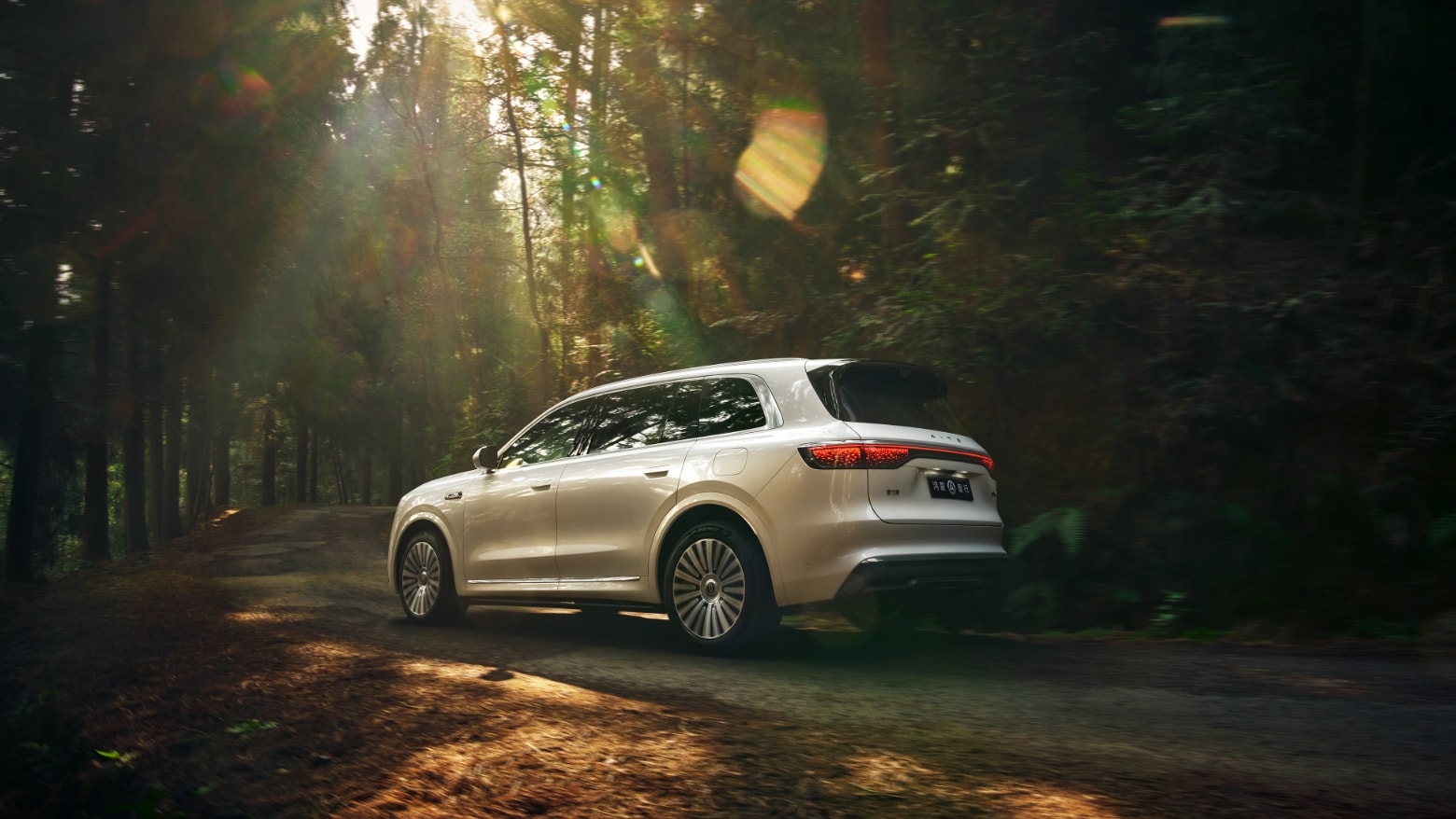 An AITO M8 in Warm Cloud White drives on a rugged natural road