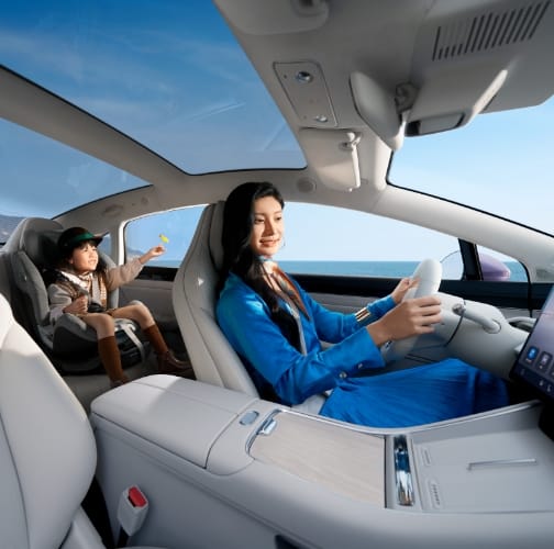 User driving the Luxeed New S7, with a child seated in a rear child safety seat, showcasing the cabin's health and safety features